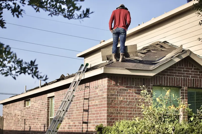 Professional roofer working on a residential roof in Northwood Center